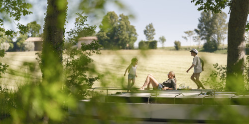 Carefree moments with kids walking and laughing on top of a moored canal boat.